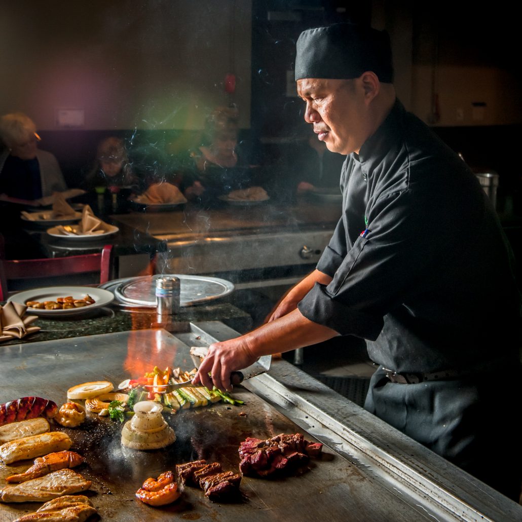 Japanese teppan yaki master chef at the grill with meat and veggies