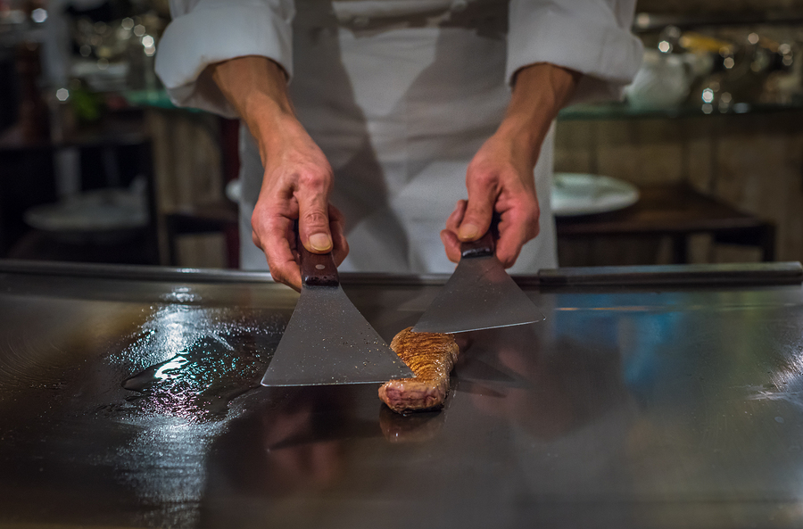 Chef cooking wagyu beef in Japanese teppanyaki restaurant