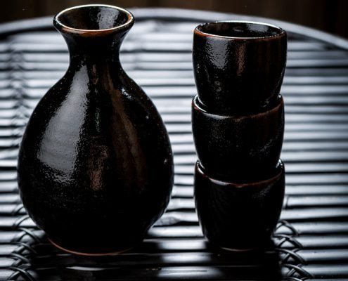 Tasty sake in black ceramics or tokkuri on black table