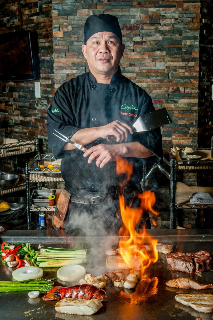 Japanese hibachi grill or teppanyaki chef in front of flaming grill