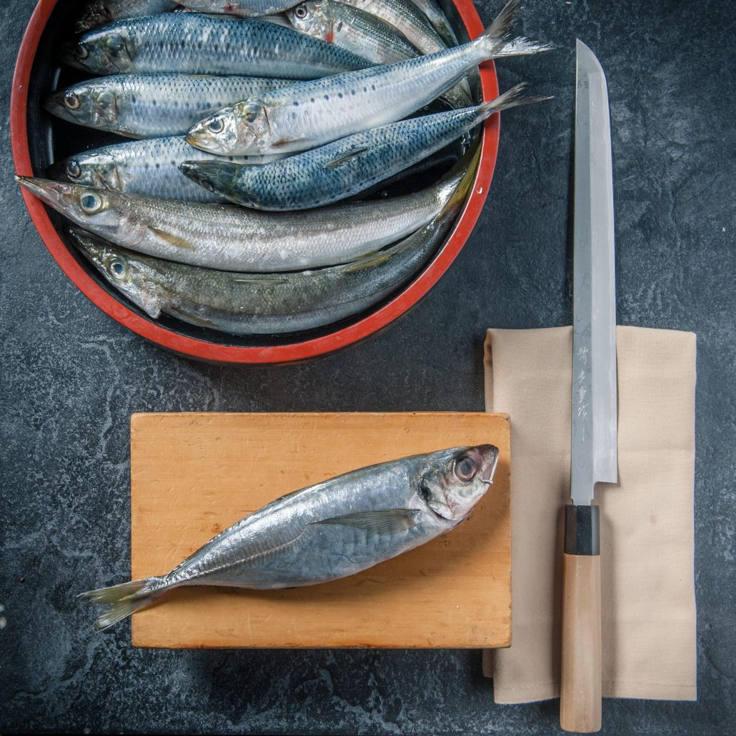 Fresh mackeral and hocho japanese knife on sushi master cutting board