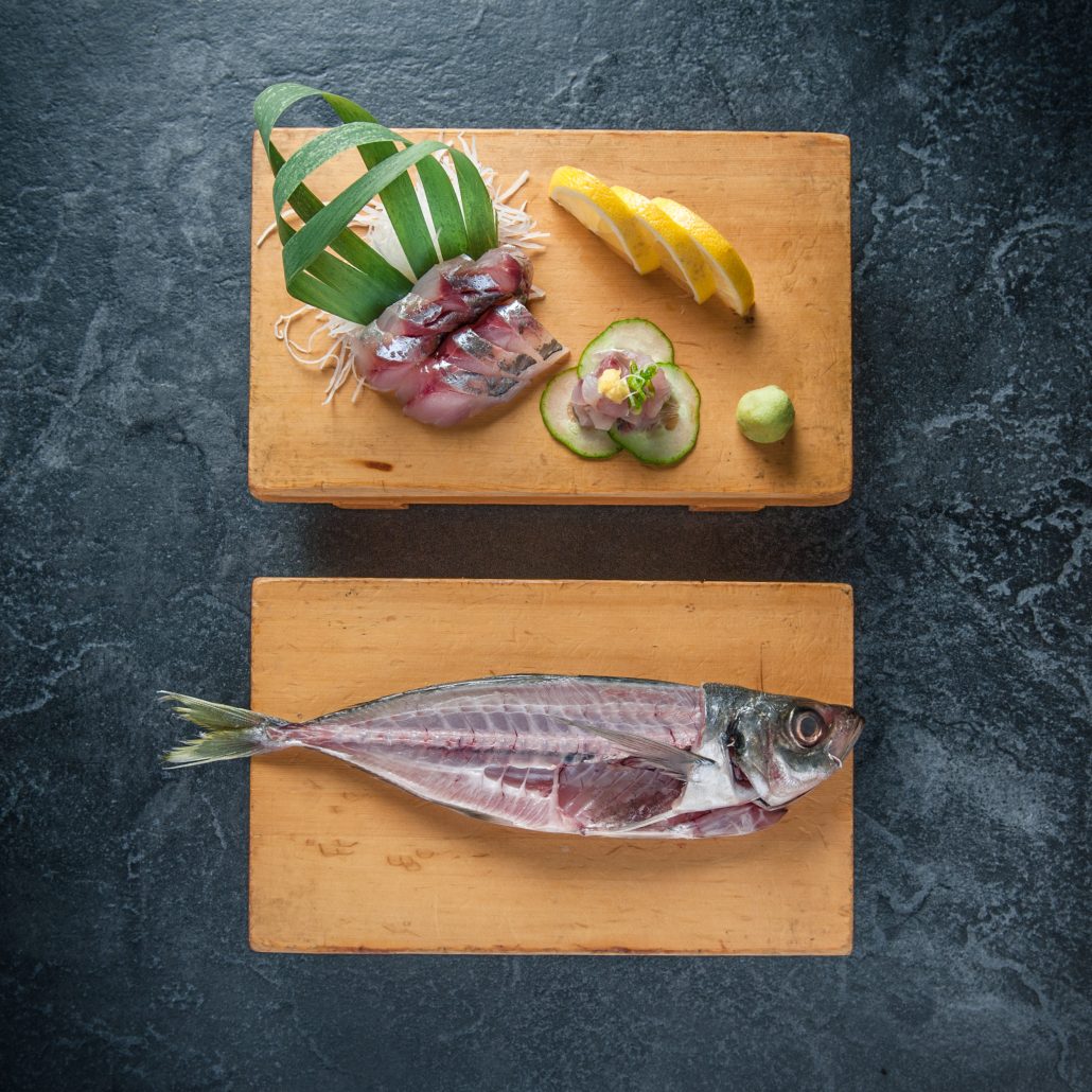Mackarel fish sliced on sushi cutting board