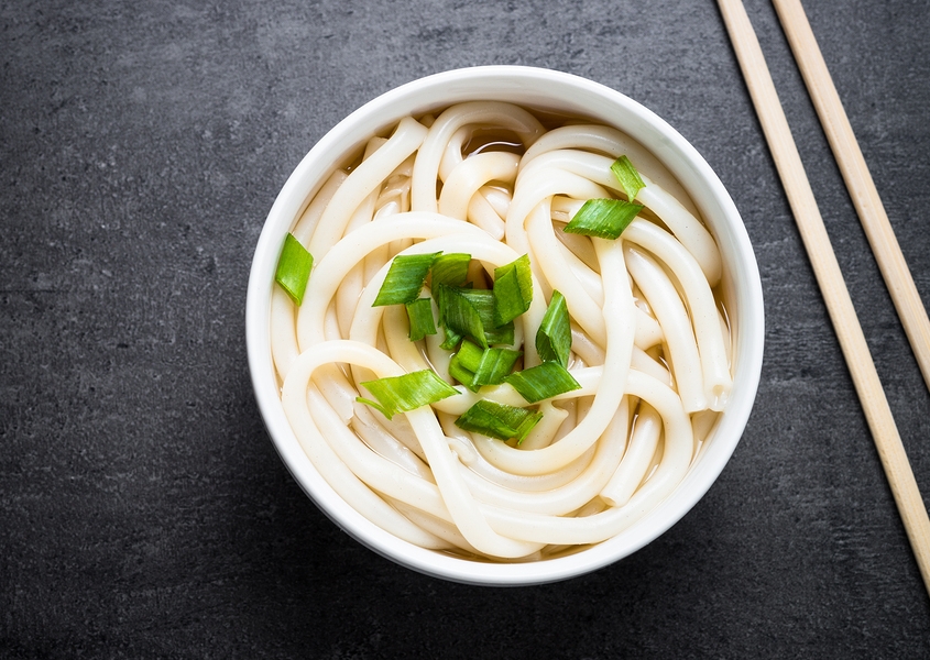 Udon Japanese noodles in a bowl on black slate table. Traditional Japanese dish.