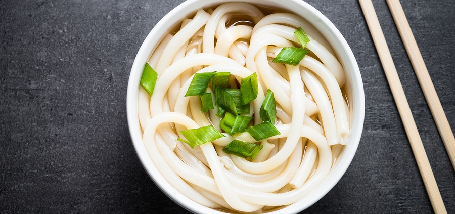 Udon Japanese noodles in a bowl on black slate table. Traditional Japanese dish.